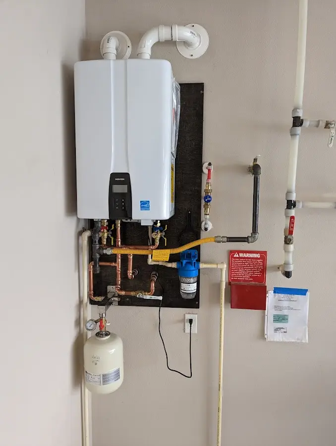 Professional plumber installing copper piping in a Cannon AFB home